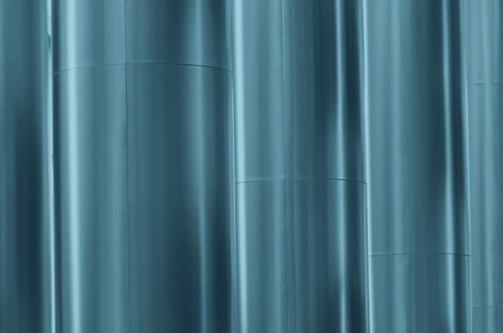 Närbild av släta, vertikala metallrör med en blå nyans.